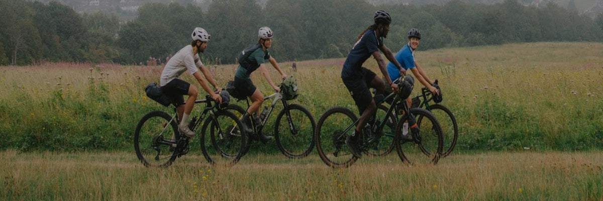 Cyclistes équipés de bagagerie Wholegrain Cycles roulant dans un champ