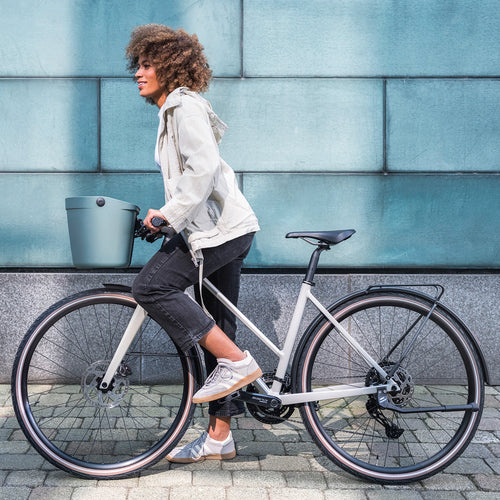 Cycliste en ville avec le panier vélo avant KLICKfix Mio Basket sage green