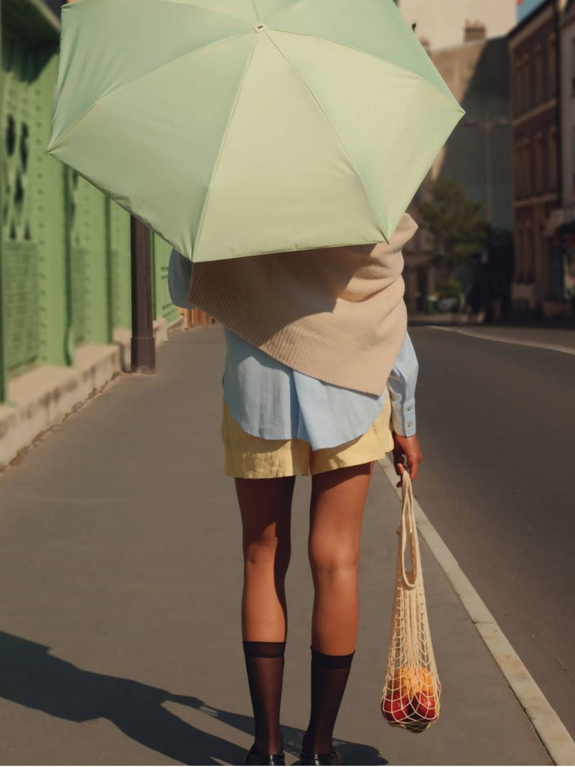 Parapluie-ombrelle Anatole vert lagon porté dans la rue