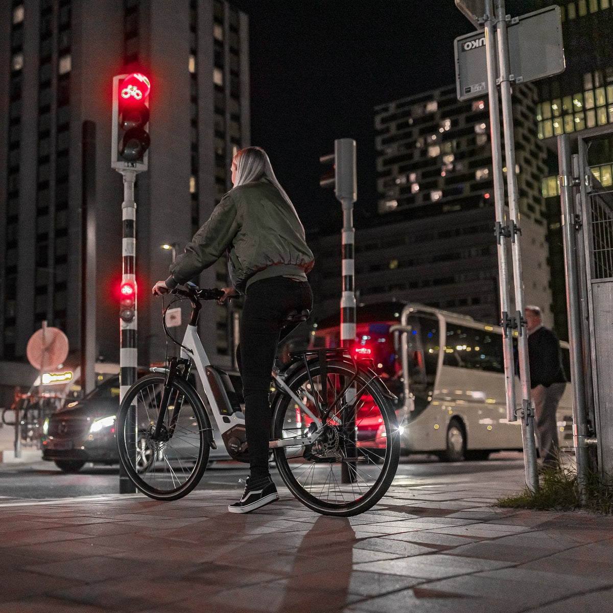 Cycliste de nuit en ville, feu arrière AXA allumé
