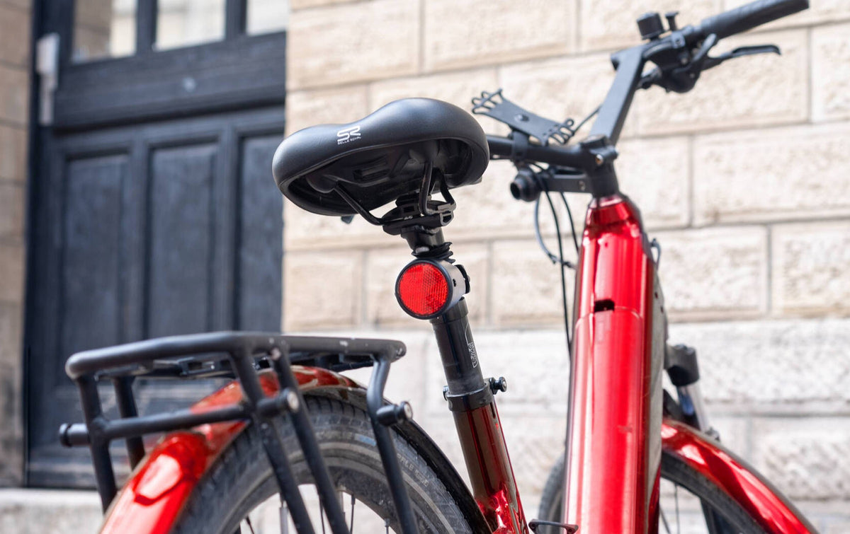 Traceur GPS vélo Invoxia caché dans le réflecteur d'un vélo électrique en ville