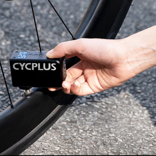 Mini pompe électrique CYCPLUS AS2 Pro branchée sur la valve d'un pneu de vélo