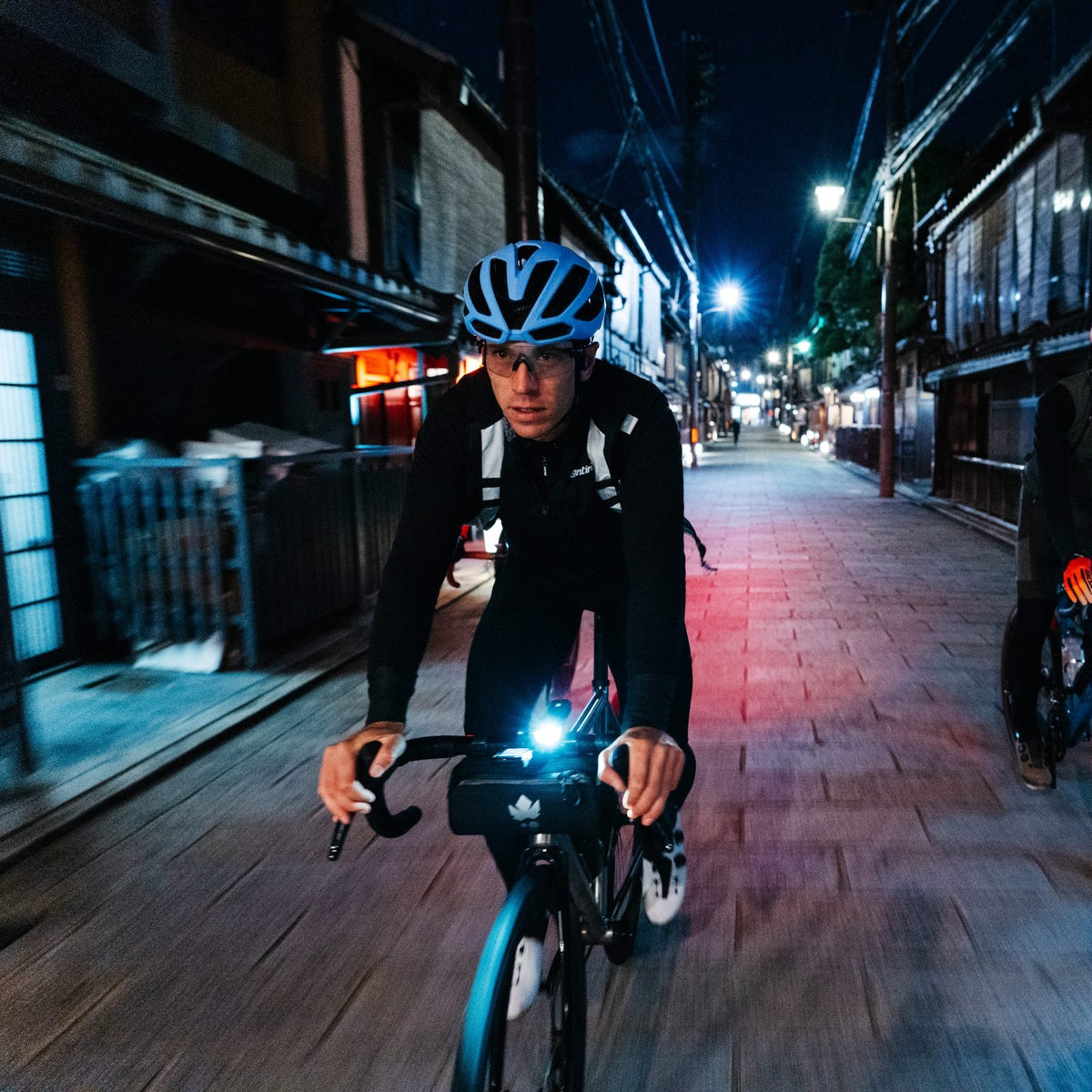 Cycliste de nuit en ville avec une sacoche de guidon Miss Grape