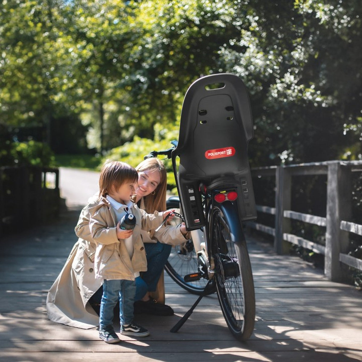 Enfant et sa maman près d'un vélo équipé d'un siège vélo enfant Polisport Koari